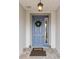 Front entry with a blue door, wreath, and welcome mat at 8916 Sw 78Th Street Rd, Ocala, FL 34481