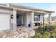 Covered front porch with brick flooring, wicker chairs, and landscaping at 8916 Sw 78Th Street Rd, Ocala, FL 34481