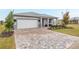 Landscaped front yard with brick pavers, and a two-car garage at 8916 Sw 78Th Street Rd, Ocala, FL 34481