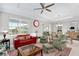 Spacious living area with red sofa, green armchairs, and large window at 8916 Sw 78Th Street Rd, Ocala, FL 34481