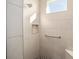 Walk-in shower with neutral tile, built-in seat, and grab bar at 9739 Sw 79Th Lane Rd, Ocala, FL 34481