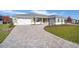 Landscaped front yard with paver driveway leading to a two-car garage at 9757 Sw 79Th Lane Rd, Ocala, FL 34481