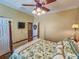 Bedroom with a wooden four-poster bed, hardwood floors, and a ceiling fan at 12152 Se 91St Ave, Summerfield, FL 34491