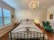 Spacious Primary bedroom with a metal bed frame, hardwood floors, and chandelier at 12152 Se 91St Ave, Summerfield, FL 34491