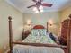 Guest bedroom with a wooden four-poster bed, hardwood floors, and a ceiling fan at 12152 Se 91St Ave, Summerfield, FL 34491