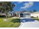 Gray house with a two-car garage and nicely landscaped yard at 15750 Sw 11Th Court Rd, Ocala, FL 34473