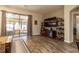 Open living area showcasing hardwood floors, large TV, and view to backyard at 15750 Sw 11Th Court Rd, Ocala, FL 34473