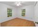 Simple bedroom with hardwood floors and ceiling fan at 5213 Se 114Th St, Belleview, FL 34420