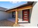 Front entrance with a red door, wood columns, and a stone walkway at 54 Dogwood Drive Loop, Ocala, FL 34472