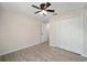 Bedroom with wood-look floors, ceiling fan, and double-door closet at 6338 Nw 14Th Ave, Ocala, FL 34475