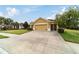 Tan house with a two-car garage and driveway at 9948 Sw 69Th Ln, Ocala, FL 34481