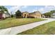 Tan house with a two-car garage and a front yard at 9948 Sw 69Th Ln, Ocala, FL 34481