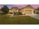 Tan house with a two-car garage, landscaping, and a walkway at 9948 Sw 69Th Ln, Ocala, FL 34481