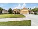 Tan house with a two-car garage and sidewalk at 9948 Sw 69Th Ln, Ocala, FL 34481