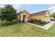 Tan house with a two-car garage and lush landscaping at 9948 Sw 69Th Ln, Ocala, FL 34481