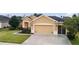 Tan house with two car garage and landscaped front yard at 9948 Sw 69Th Ln, Ocala, FL 34481