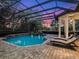 Enclosed pool and patio area at dusk with lounge chairs at 1435 Se 73Rd Pl, Ocala, FL 34480