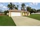 Front view of a single-story house, featuring a white garage door, a red-trimmed entryway, and a large front yard at 16690 Sw 50Th Ave, Ocala, FL 34473