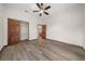 Bedroom with wood-look flooring, double doors to closet, and ceiling fan at 3803 Se 6Th Ave, Ocala, FL 34480