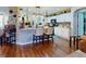 Open kitchen with white cabinets, large island, and wood flooring at 8327 Sw 79Th Cir, Ocala, FL 34476
