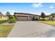 House exterior with three car garage and a large driveway at 9733 Sw 74Th Pl, Ocala, FL 34481