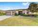 Single-story house with three-car garage and manicured lawn at 9733 Sw 74Th Pl, Ocala, FL 34481