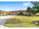 Single-story house with three-car garage and lush landscaping at 9733 Sw 74Th Pl, Ocala, FL 34481