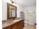 Bathroom with granite countertop, wood cabinets, and tiled shower at 9901 Nw 6Th Ct, Ocala, FL 34475