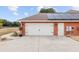 White double garage door with black hardware and solar panels at 9901 Nw 6Th Ct, Ocala, FL 34475