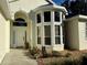 Inviting entryway with a white door, large windows, and landscaping at 10654 Sw 71St Cir, Ocala, FL 34476