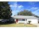 Single-story home with a red front door and attached garage at 11495 Sw 138Th Ln, Dunnellon, FL 34432