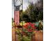 Landscaped garden with roses, a bench, and an American flag at 11495 Sw 138Th Ln, Dunnellon, FL 34432