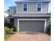 Two-story house with gray siding, brick driveway, and a two-car garage at 1609 Chelsea Manor Cir, Deland, FL 32724