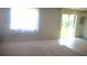 Bright living room with carpet flooring, large window, and sliding glass doors at 1609 Chelsea Manor Cir, Deland, FL 32724