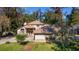 Two-story house with a large backyard and driveway, surrounded by lush trees at 1825 Se 36Th Pl, Ocala, FL 34471