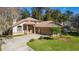 Two-story house with a two-car garage and a spacious yard surrounded by trees at 1825 Se 36Th Pl, Ocala, FL 34471