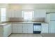 White kitchen features ample cabinetry, a built-in microwave, and dishwasher at 2439 Nw 55Th Avenue Rd, Ocala, FL 34482