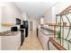 Galley-style kitchen featuring black appliances, light wood cabinets, and dark countertops at 5239 Se 92Nd Street, Ocala, FL 34480