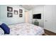 Bedroom with floral bedding, wall-mounted TV, and hardwood floors at 9551 Sw 70Th Loop, Ocala, FL 34481