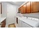 Bright laundry room with washer, dryer, cabinets, and exterior access at 9551 Sw 70Th Loop, Ocala, FL 34481