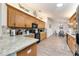 Modern kitchen with wood cabinets, granite countertops, black appliances, and a view of the dining area at 9199 Se 135Th St, Summerfield, FL 34491