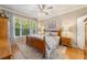 Main bedroom with wood flooring, large windows, and a ceiling fan at 9570 Sw 70Th Loop, Ocala, FL 34481