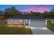 New construction home at sunset with a two-car garage and driveway at 10178 Sw 137 Ave, Dunnellon, FL 34432