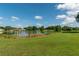 Scenic view of the golf course with a pond, trees, and homes in the background at 8475 Sw 109Th Lane Rd, Ocala, FL 34481