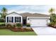 Single-story home with two-car garage, stone accents, and landscaping at 8552 Pinecrest Trl, Wildwood, FL 34785