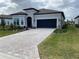 Single-story home with gray exterior, paver driveway, and landscaping at 8750 Sw 59Th Lane Rd, Ocala, FL 34481