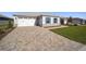 Home's exterior boasts a paver driveway and landscaped lawn at 9781 Sw 79Th Lane Rd, Ocala, FL 34481