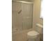 Bathroom with sliding glass shower doors, toilet, and tiled floor at 11388 Sw 139Th St, Dunnellon, FL 34432