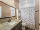 Clean bathroom with granite vanity and floral shower curtain at 1166 Cr 441, Lake Panasoffkee, FL 33538