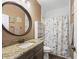 Bathroom with granite countertop, round mirror, and shower at 1166 Cr 441, Lake Panasoffkee, FL 33538